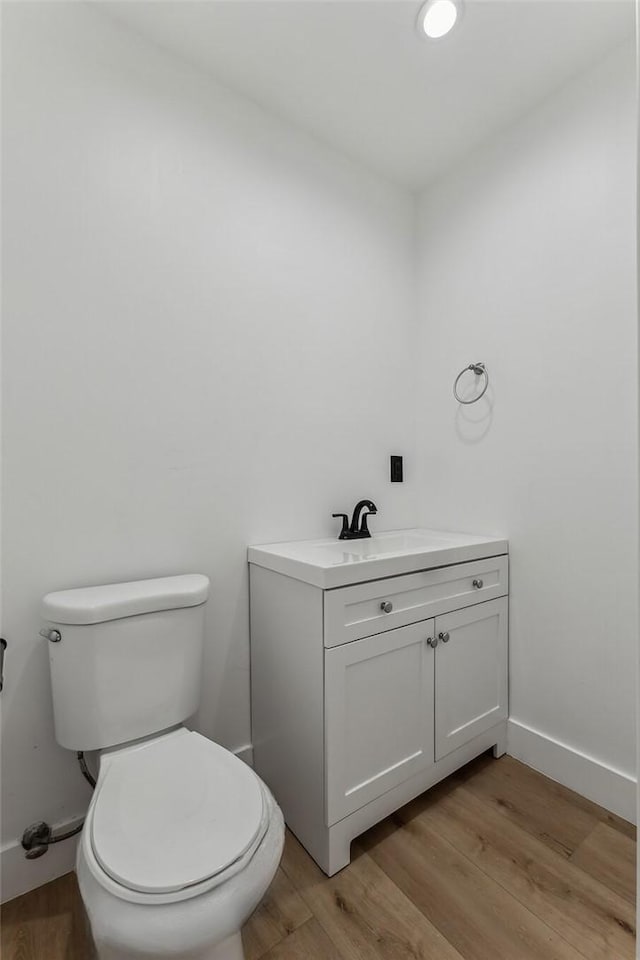 bathroom featuring toilet, hardwood / wood-style floors, and vanity