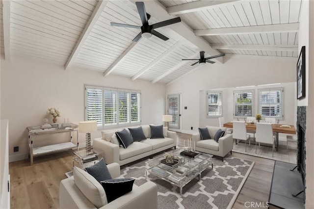 living room with ceiling fan, dark hardwood / wood-style flooring, and vaulted ceiling with beams