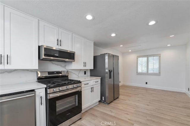 1536 Wollacott St, Redondo Beach, CA 90278 - kitchen with appliances with stainless steel finishes, light countertops, white cabinets, light wood finished floors, and baseboards