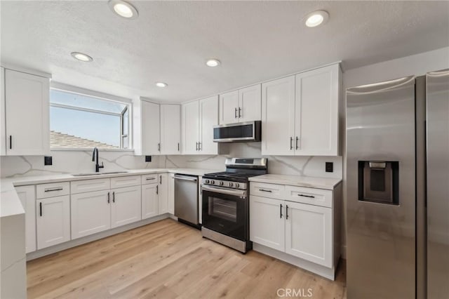 1536 Wollacott St, Redondo Beach, CA 90278 - kitchen featuring stainless steel appliances, a sink, white cabinets, a textured ceiling, and tasteful backsplash