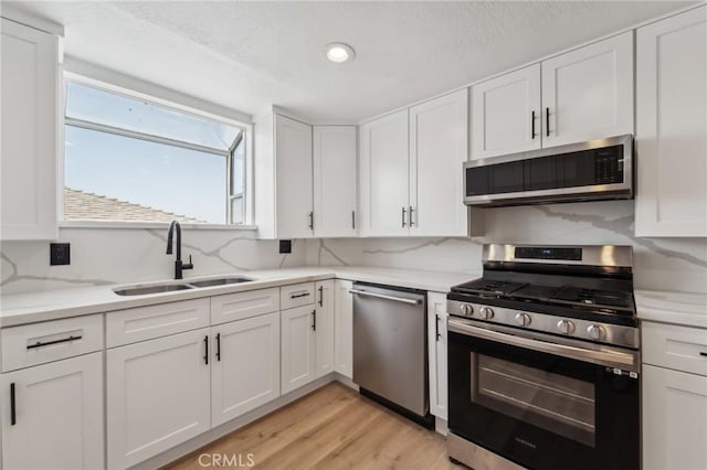 1536 Wollacott St, Redondo Beach, CA 90278 - kitchen with appliances with stainless steel finishes, a sink, white cabinetry, light countertops, and healthy amount of natural light