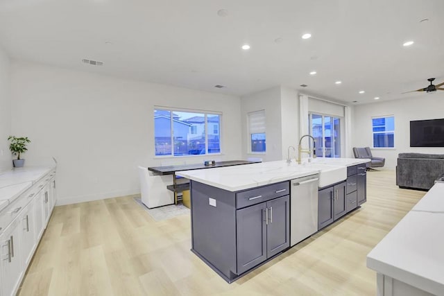 kitchen featuring dishwasher, ceiling fan, light stone counters, white cabinets, and sink