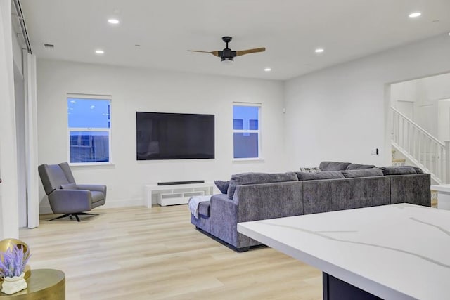 living room with ceiling fan and light hardwood / wood-style flooring