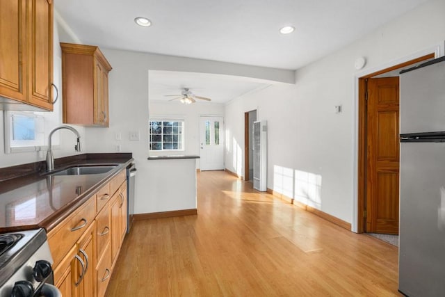 kitchen with sink, stainless steel appliances, ceiling fan, and light hardwood / wood-style floors