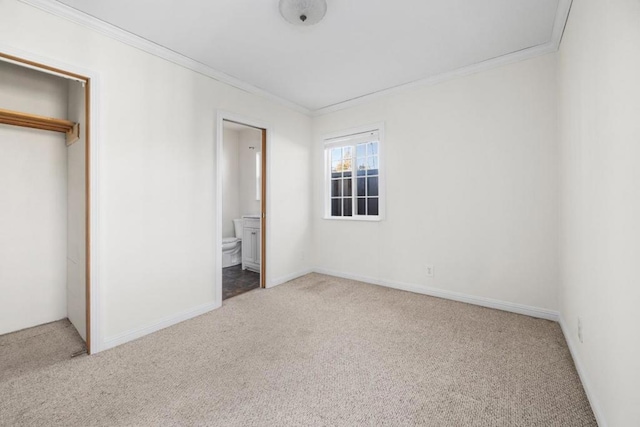 unfurnished bedroom with ensuite bath, carpet floors, a closet, and crown molding