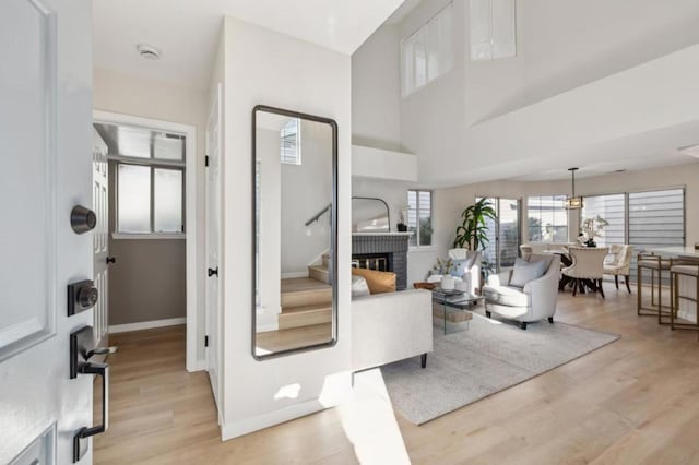 living room featuring a brick fireplace and light wood-type flooring