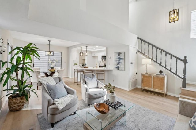 living room featuring an inviting chandelier and light hardwood / wood-style flooring