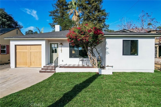 back of house with a garage and a yard