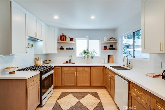 kitchen with white cabinets, dishwasher, sink, and gas stove