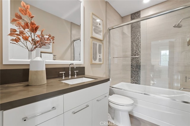 full bathroom with toilet, combined bath / shower with glass door, and vanity