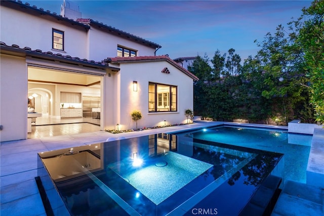 pool at dusk with a patio