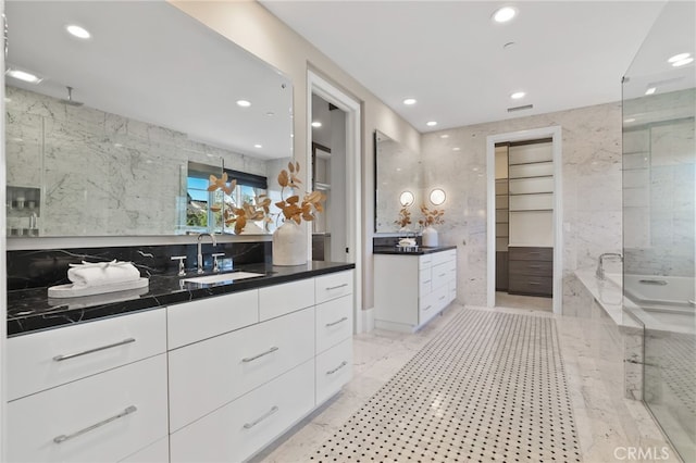 kitchen with sink, tile walls, and white cabinetry