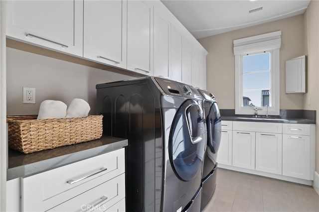 laundry area with sink, washer and dryer, and cabinets