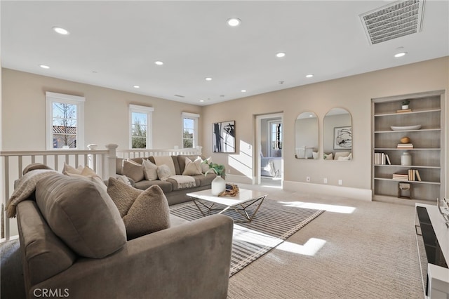 living room featuring light colored carpet and a healthy amount of sunlight