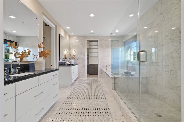 bathroom featuring vanity and independent shower and bath