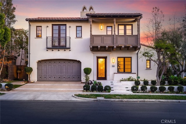 mediterranean / spanish-style house featuring a balcony and a garage