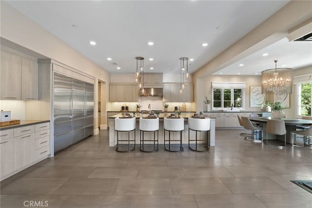 kitchen featuring pendant lighting, extractor fan, a wealth of natural light, and a kitchen breakfast bar