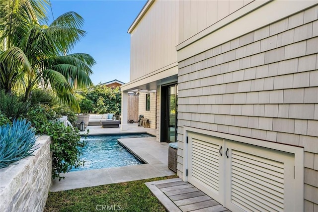 view of swimming pool with pool water feature and outdoor lounge area