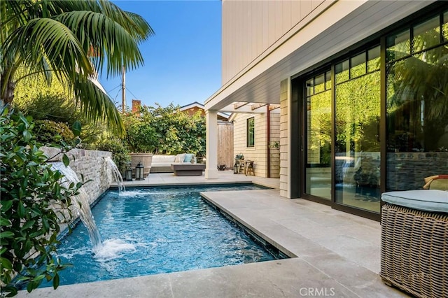 view of pool featuring a patio, pool water feature, and outdoor lounge area