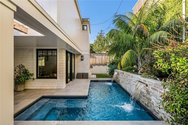 view of pool with a patio and pool water feature