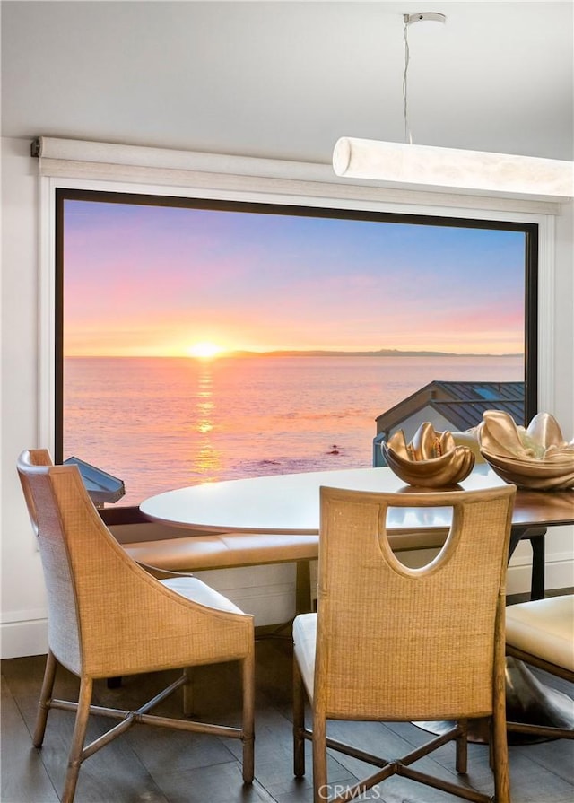 dining area with a water view and hardwood / wood-style flooring