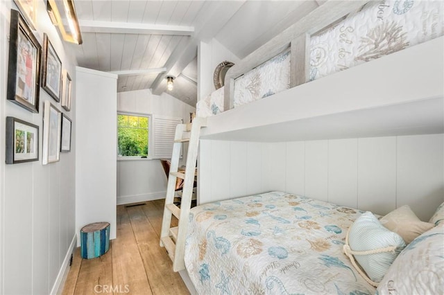 bedroom featuring lofted ceiling with beams, light hardwood / wood-style flooring, and wood ceiling