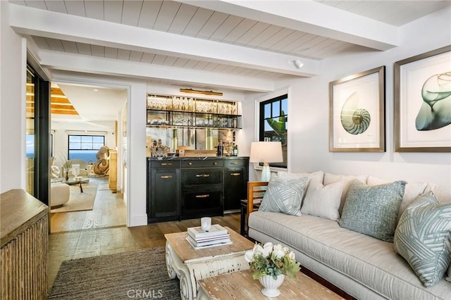 living room featuring beam ceiling, indoor bar, and dark hardwood / wood-style flooring