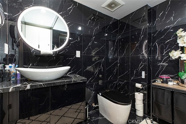 bathroom with sink, toilet, and tile walls