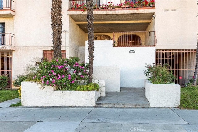 view of exterior entry with a balcony