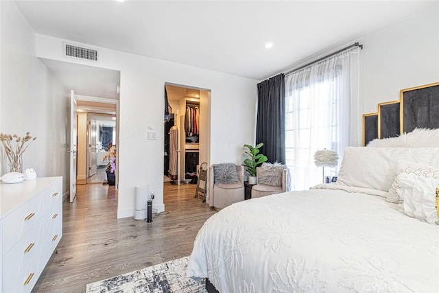 bedroom featuring light wood-type flooring, a closet, and a spacious closet