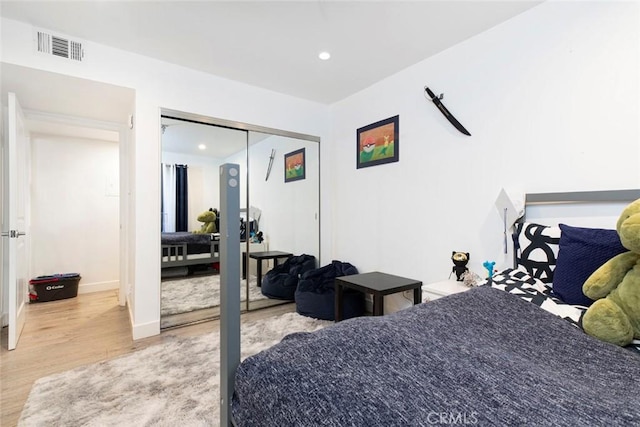 bedroom with light wood-type flooring and a closet