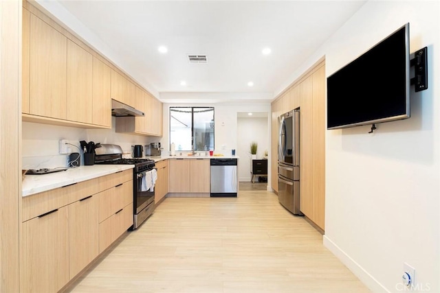 kitchen featuring appliances with stainless steel finishes, light hardwood / wood-style flooring, light brown cabinetry, and sink