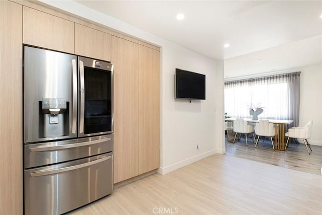 kitchen featuring light hardwood / wood-style floors, stainless steel fridge with ice dispenser, and light brown cabinets