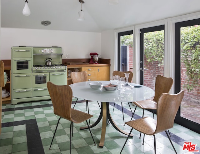 dining room featuring a wall of windows and vaulted ceiling