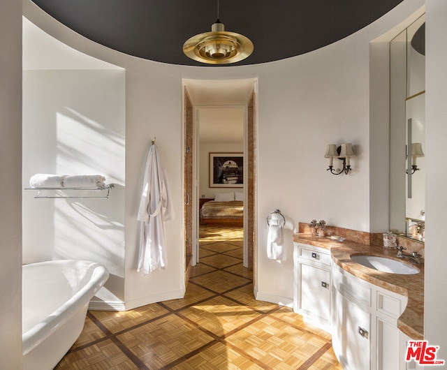 bathroom featuring a bathing tub, parquet flooring, and vanity