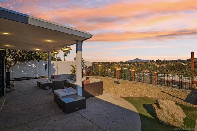 patio terrace at dusk with an outdoor living space with a fire pit