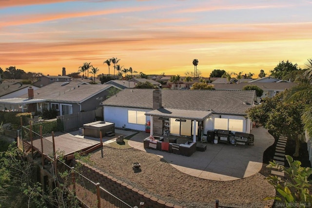 back house at dusk with a patio and an outdoor living space