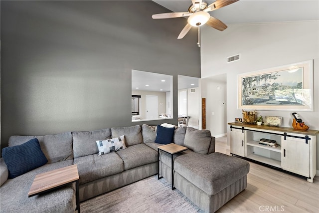 living room featuring ceiling fan, light wood-type flooring, and high vaulted ceiling