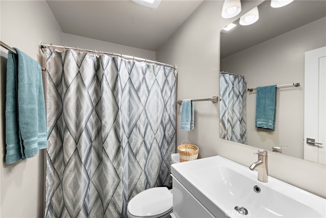 bathroom featuring sink, toilet, and curtained shower