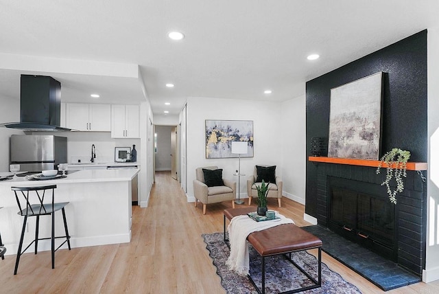 living room with a fireplace and light wood-type flooring