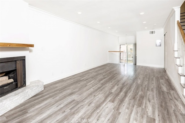 unfurnished living room featuring ornamental molding and light hardwood / wood-style flooring