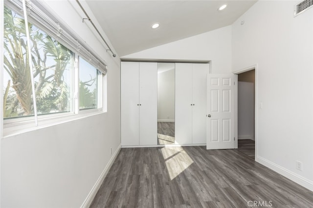 unfurnished bedroom featuring dark hardwood / wood-style flooring, a closet, and lofted ceiling