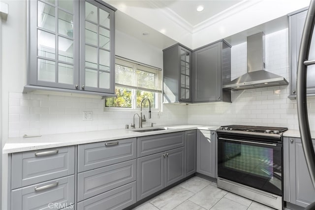 kitchen with gas range, gray cabinetry, and wall chimney range hood