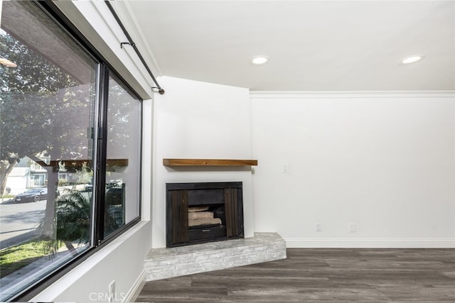 unfurnished living room featuring a fireplace, crown molding, and dark hardwood / wood-style floors