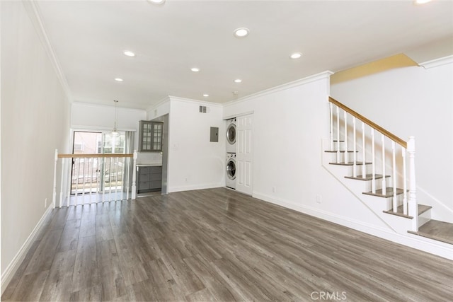 unfurnished living room with stacked washer and clothes dryer, crown molding, and dark hardwood / wood-style floors