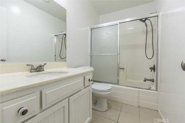 full bathroom with toilet, combined bath / shower with glass door, tile patterned flooring, and vanity