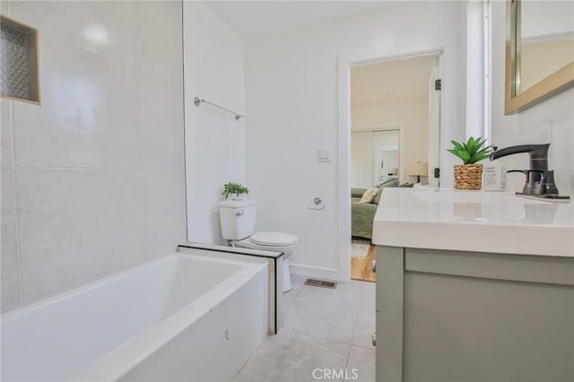 bathroom with a tub to relax in, tile patterned flooring, vanity, and toilet