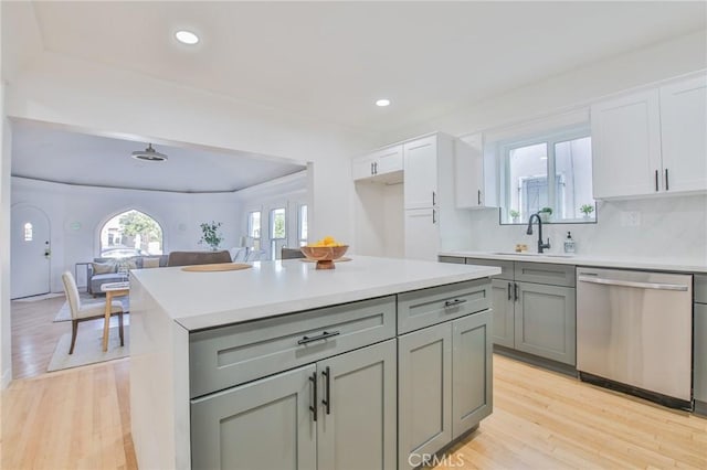 kitchen with sink, white cabinets, light hardwood / wood-style flooring, and dishwasher