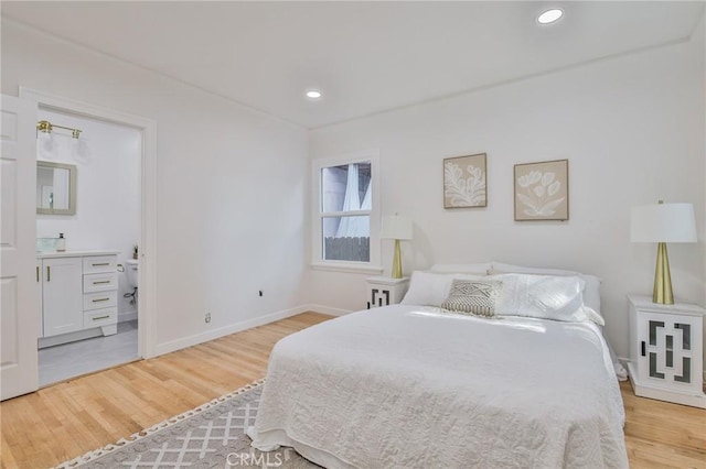 bedroom with light hardwood / wood-style flooring and connected bathroom