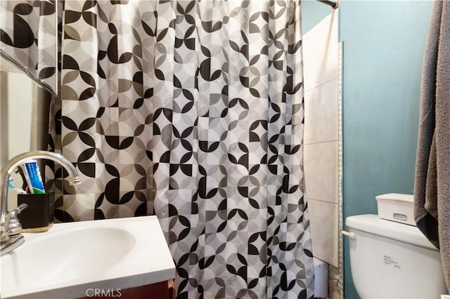 bathroom featuring walk in shower, toilet, and sink